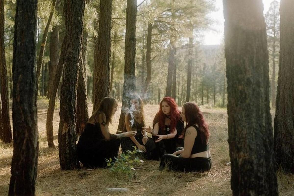 tre ragazze sedute a terra in una foresta