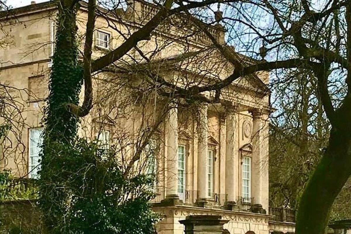 un grande edificio in pietra con un albero di fronte