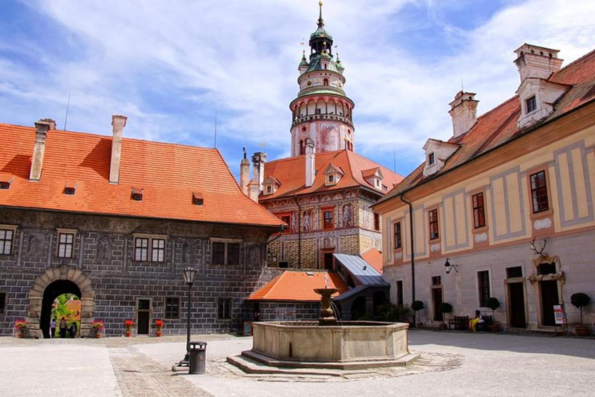 stará budova s hodinovou věží a fontánou