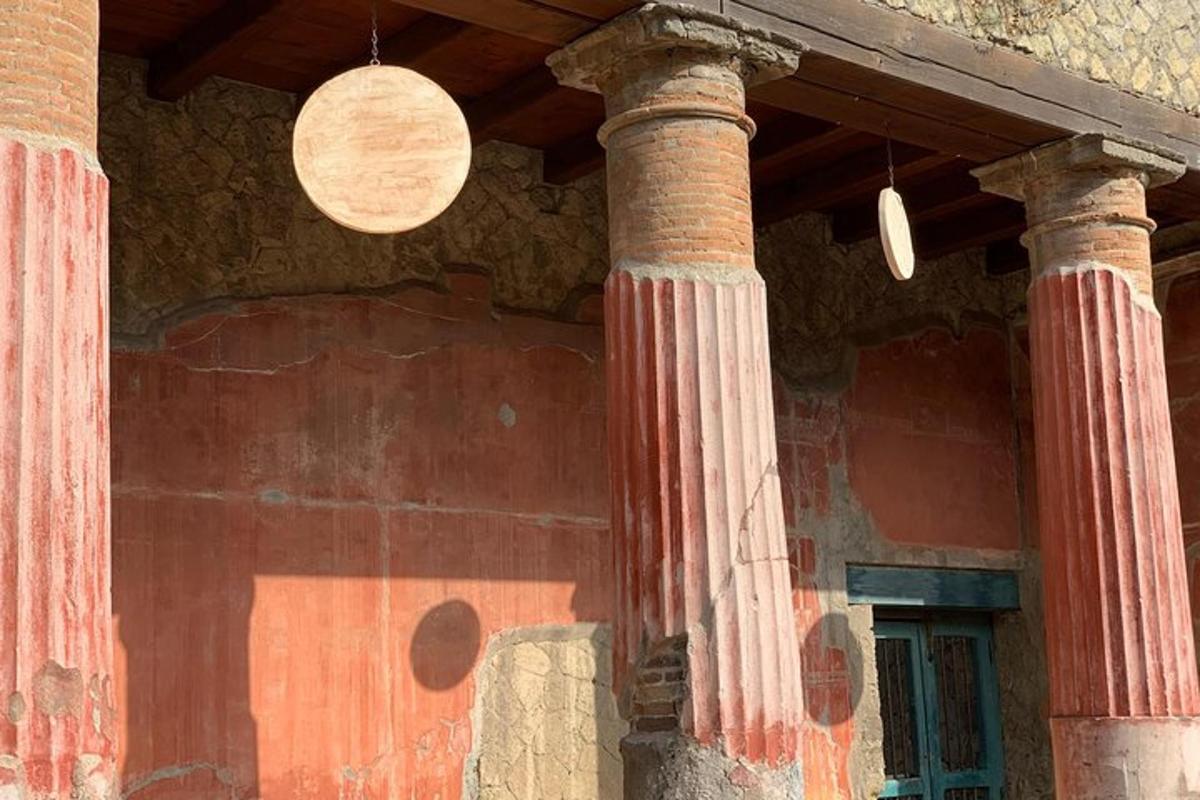 ēka ar divām kolonnām un pulksteni pie sienas