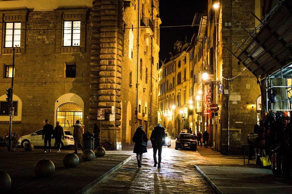 um grupo de pessoas caminhando por uma rua à noite
