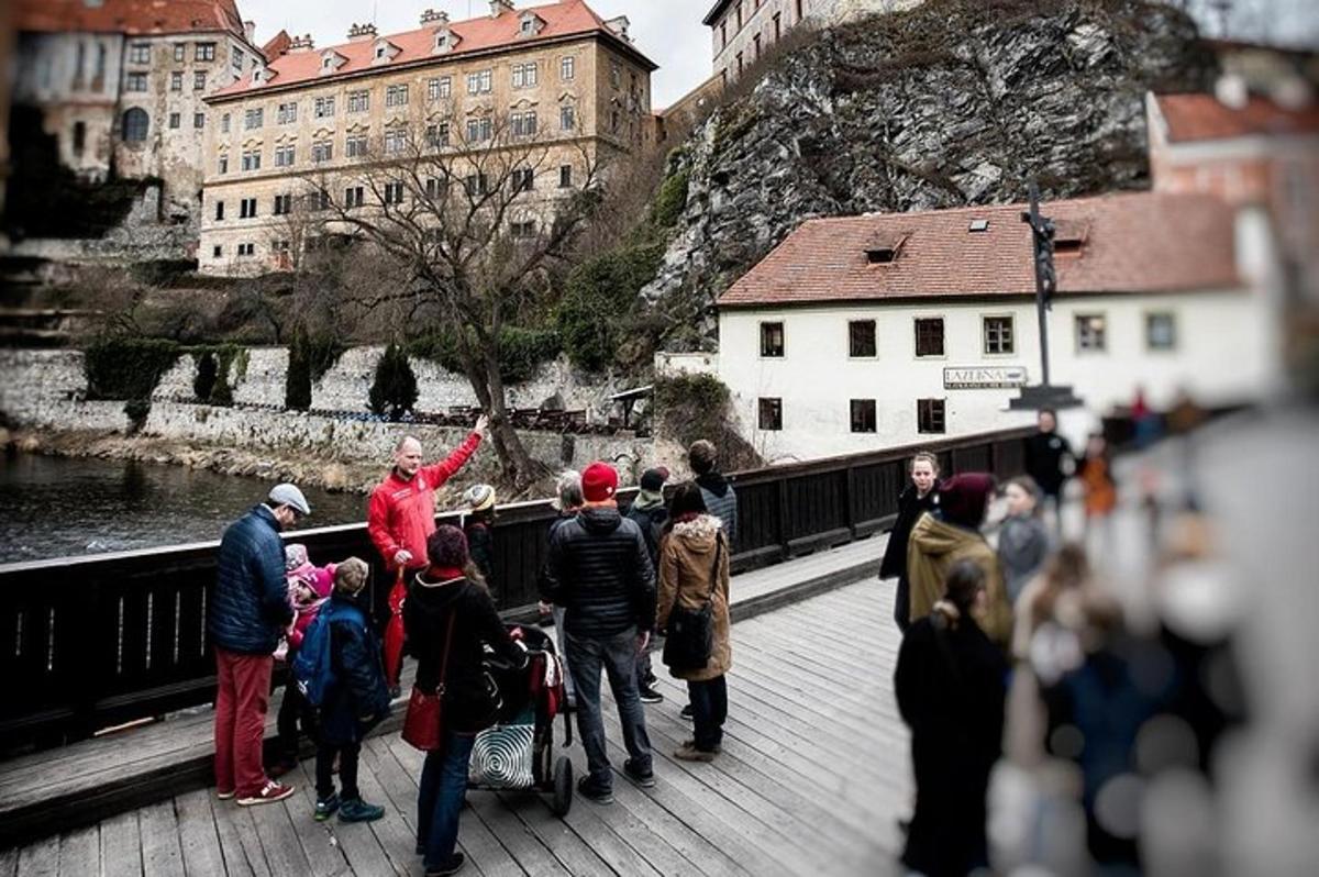 a group of people standing on a bridge near the water
