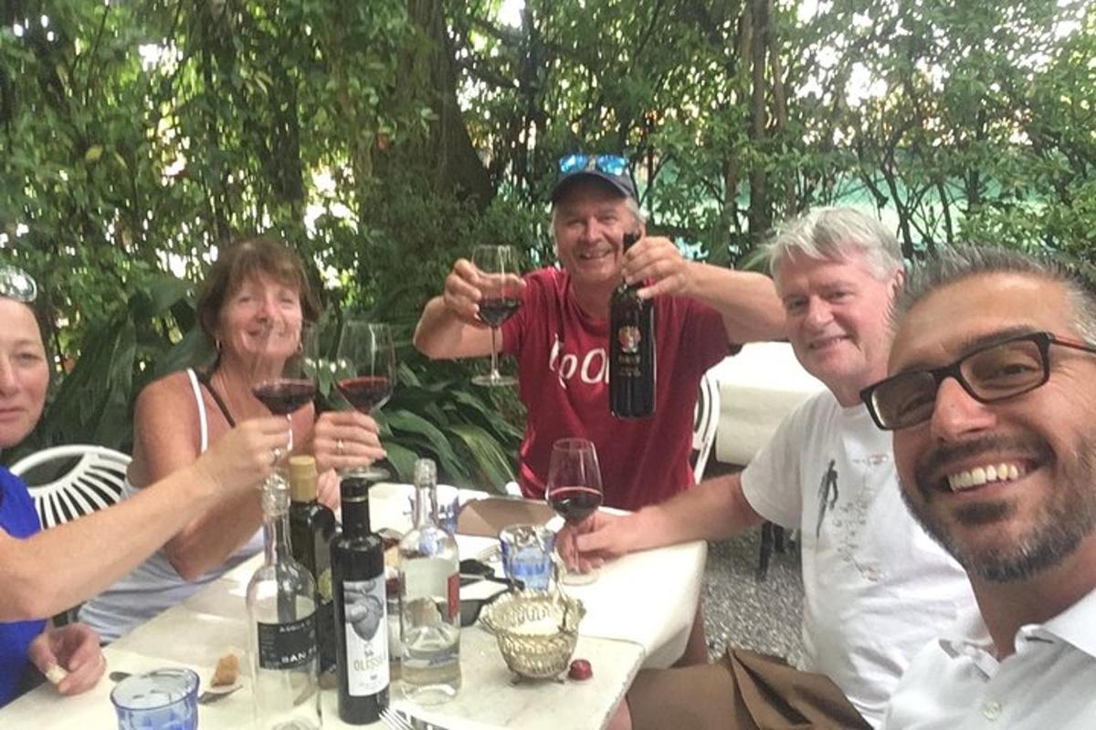 un gruppo di persone sedute a un tavolo che bevono vino