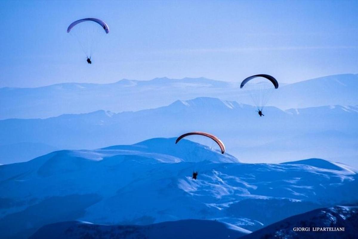 un gruppo di parapendisti che volano sopra l'acqua