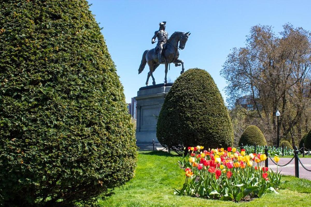 a statue of a man on a horse and some flowers