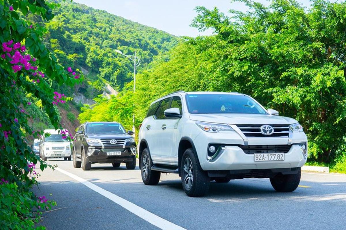 en hvit Toyota-lastebil som kjører nedover en vei