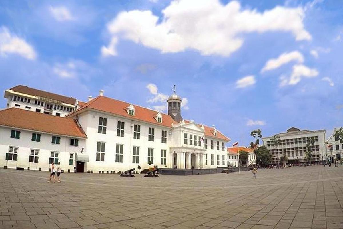 un grand bâtiment blanc avec une tour d'horloge au sommet
