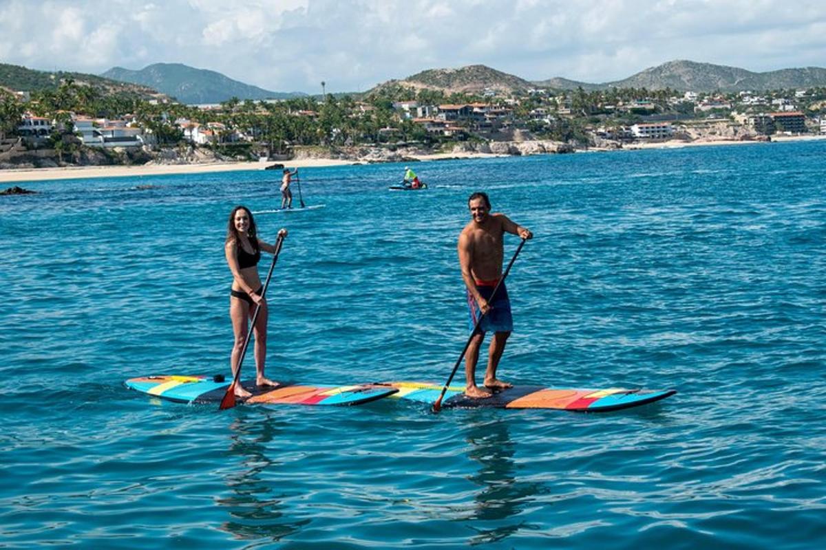 two people are standing on paddle boards in the water