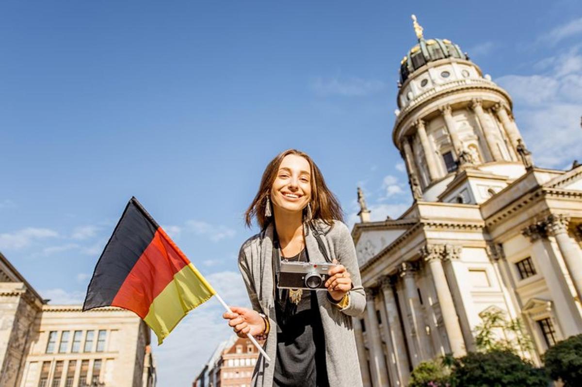 o femeie care ține un steag și o cameră foto în fața unei clădiri