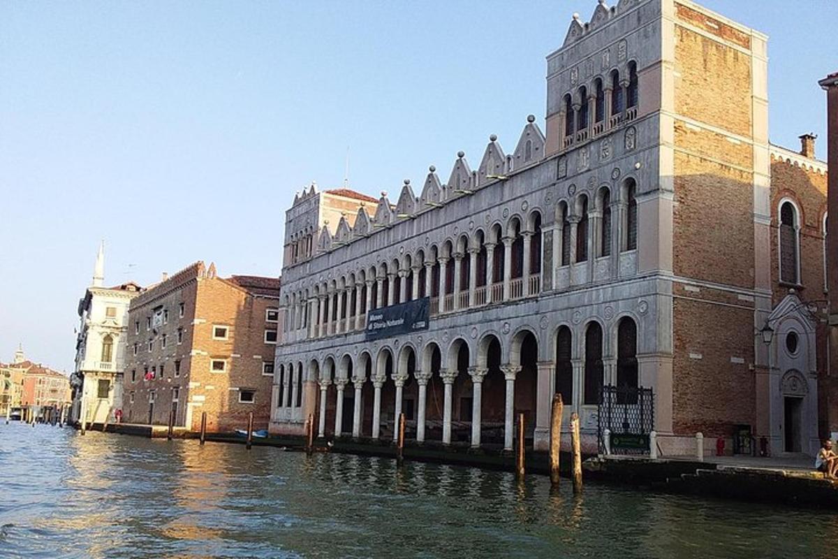 un grande edificio sull'acqua accanto ad alcuni edifici