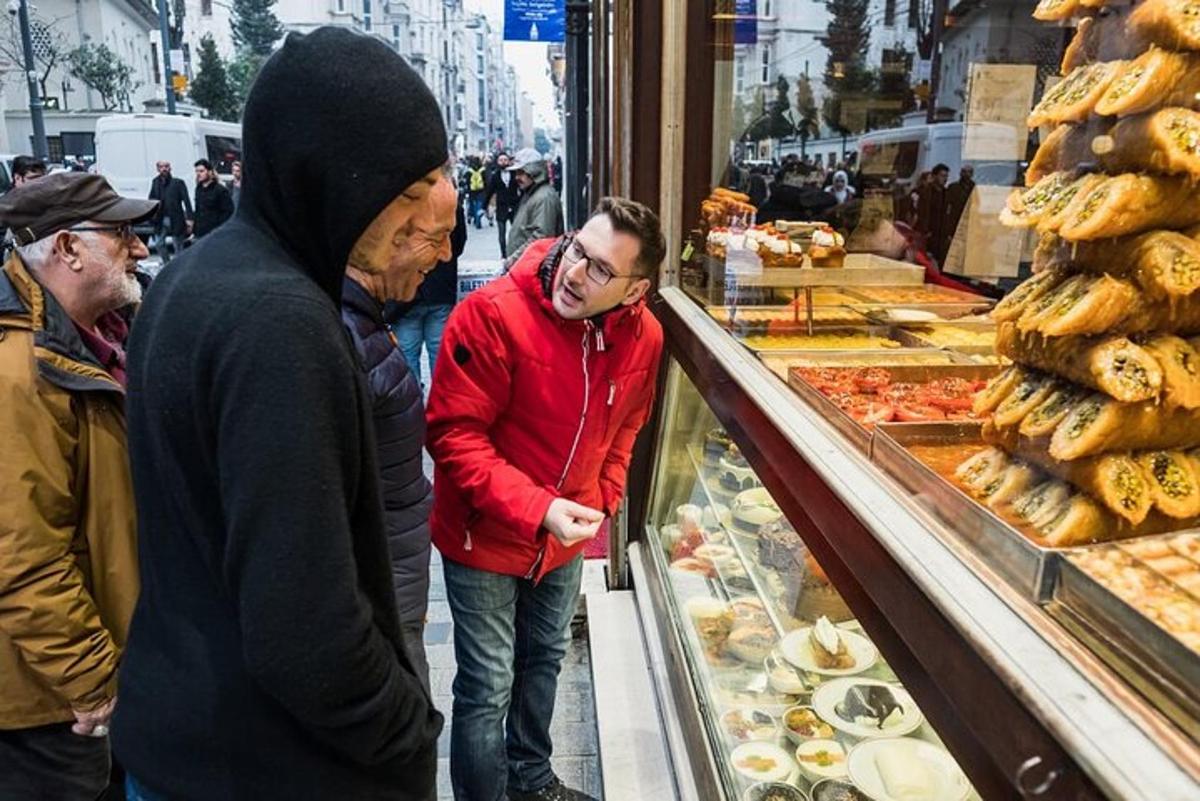 hópur fólks stendur í kringum sýningarskáp í bakaríi