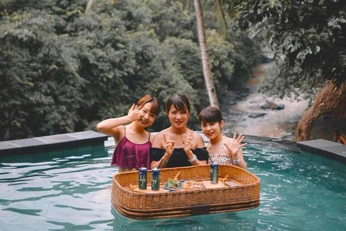 ba đứa trẻ trong một hồ bơi có một chiếc thuyền trên mặt nước