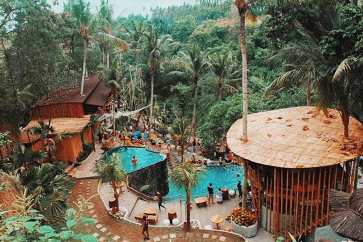 một hồ bơi lớn tại một khu nghỉ dưỡng có nhiều người ở trong đó