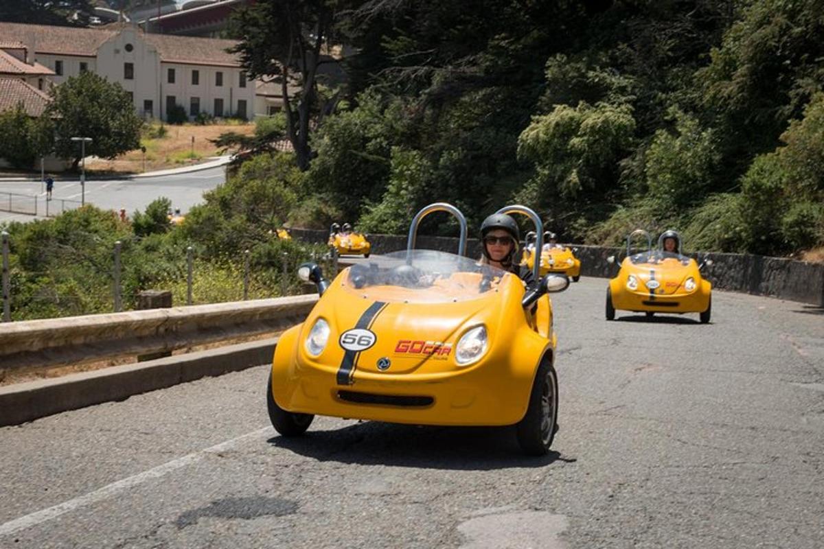 a man riding a small yellow car on a road