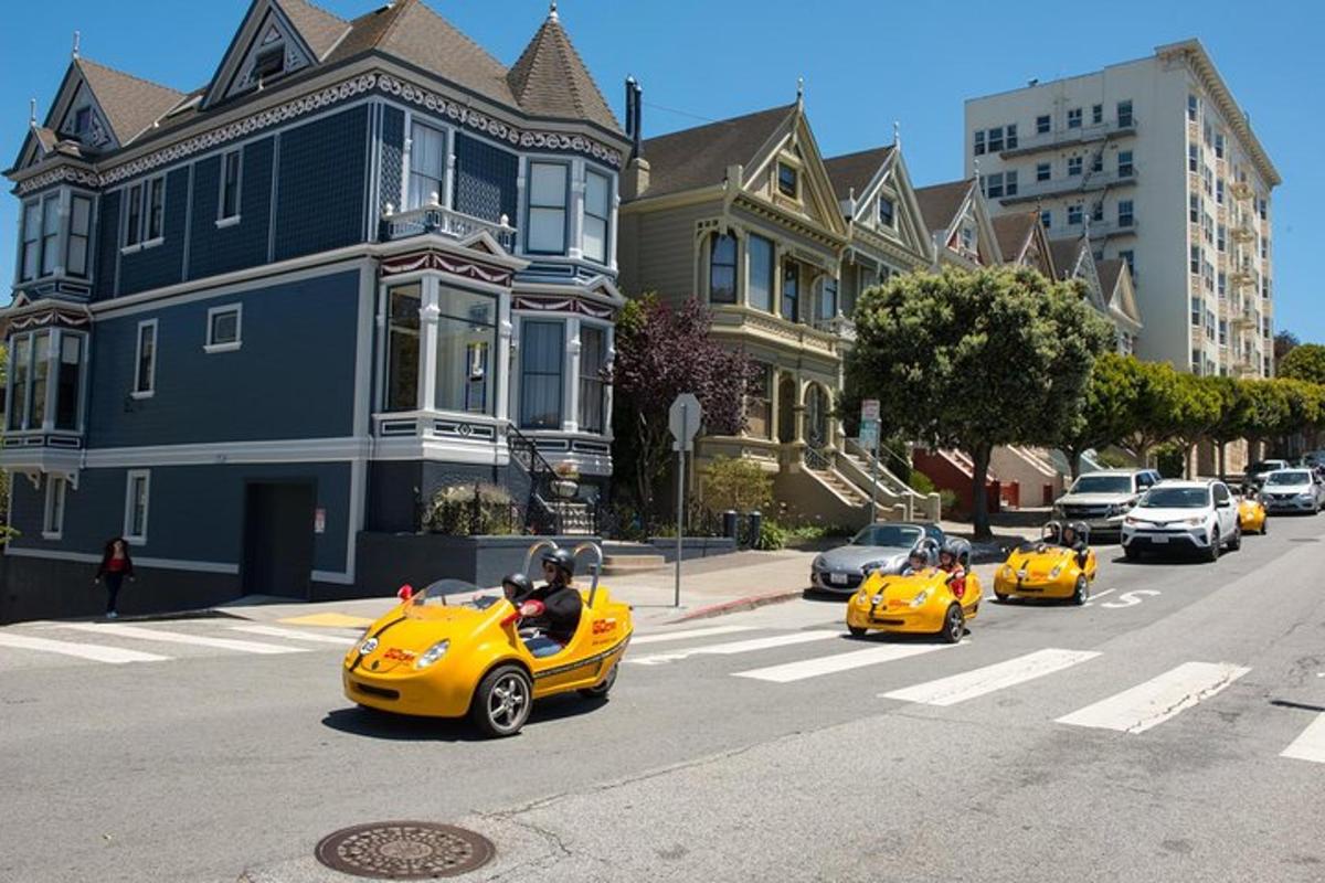 a group of yellow cars driving down a street