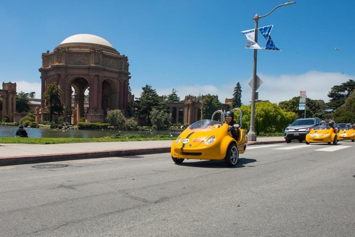 a group of yellow cars driving down a street
