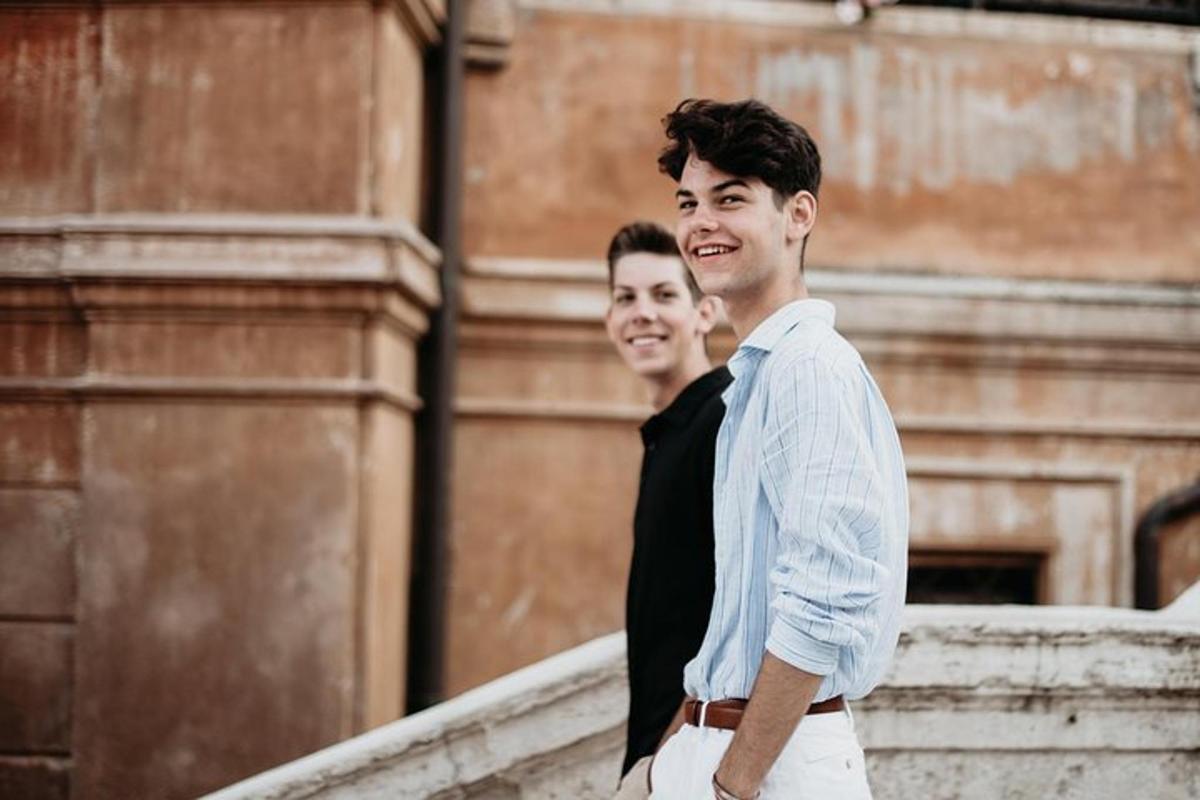 two men standing next to each other in front of a building