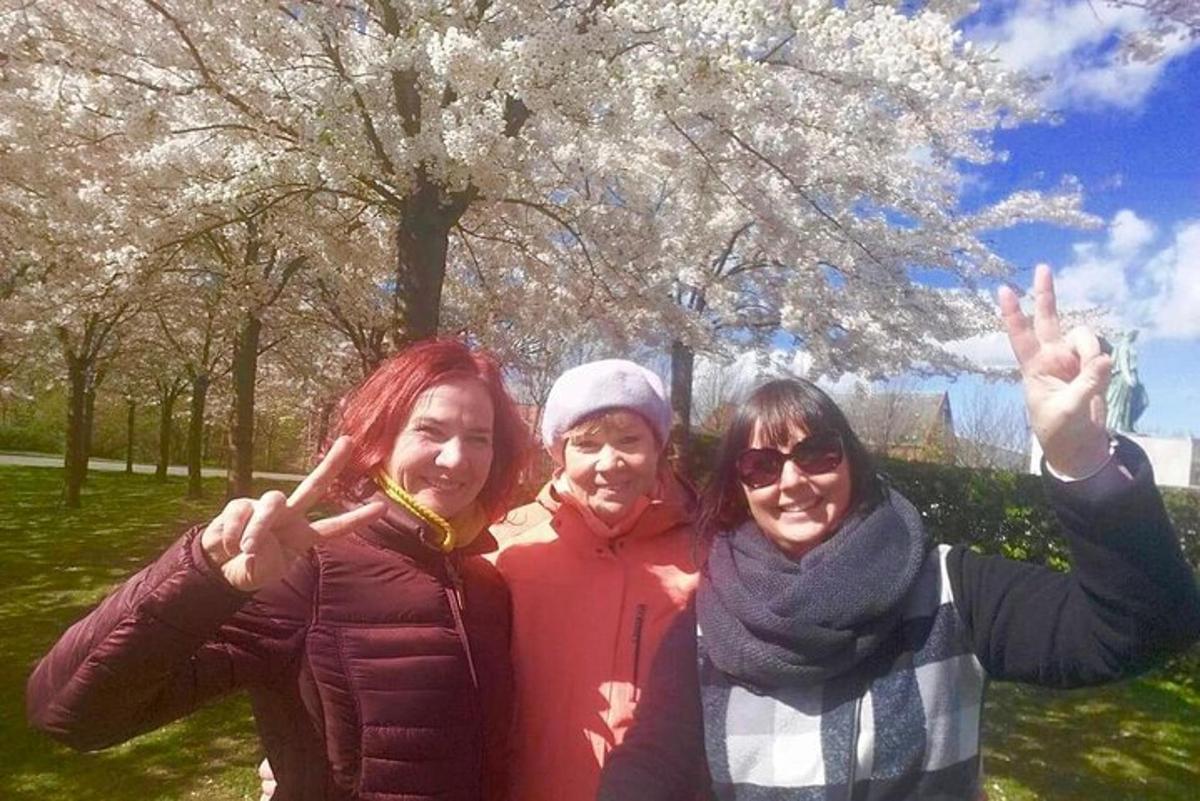 tři ženy pózující pro fotografii před stromem