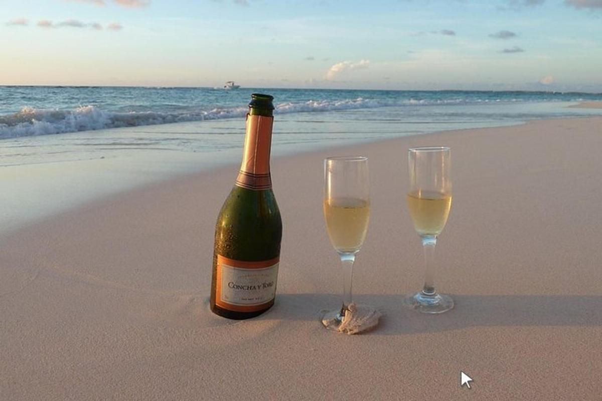 eine Flasche Wein und zwei Gläser am Strand