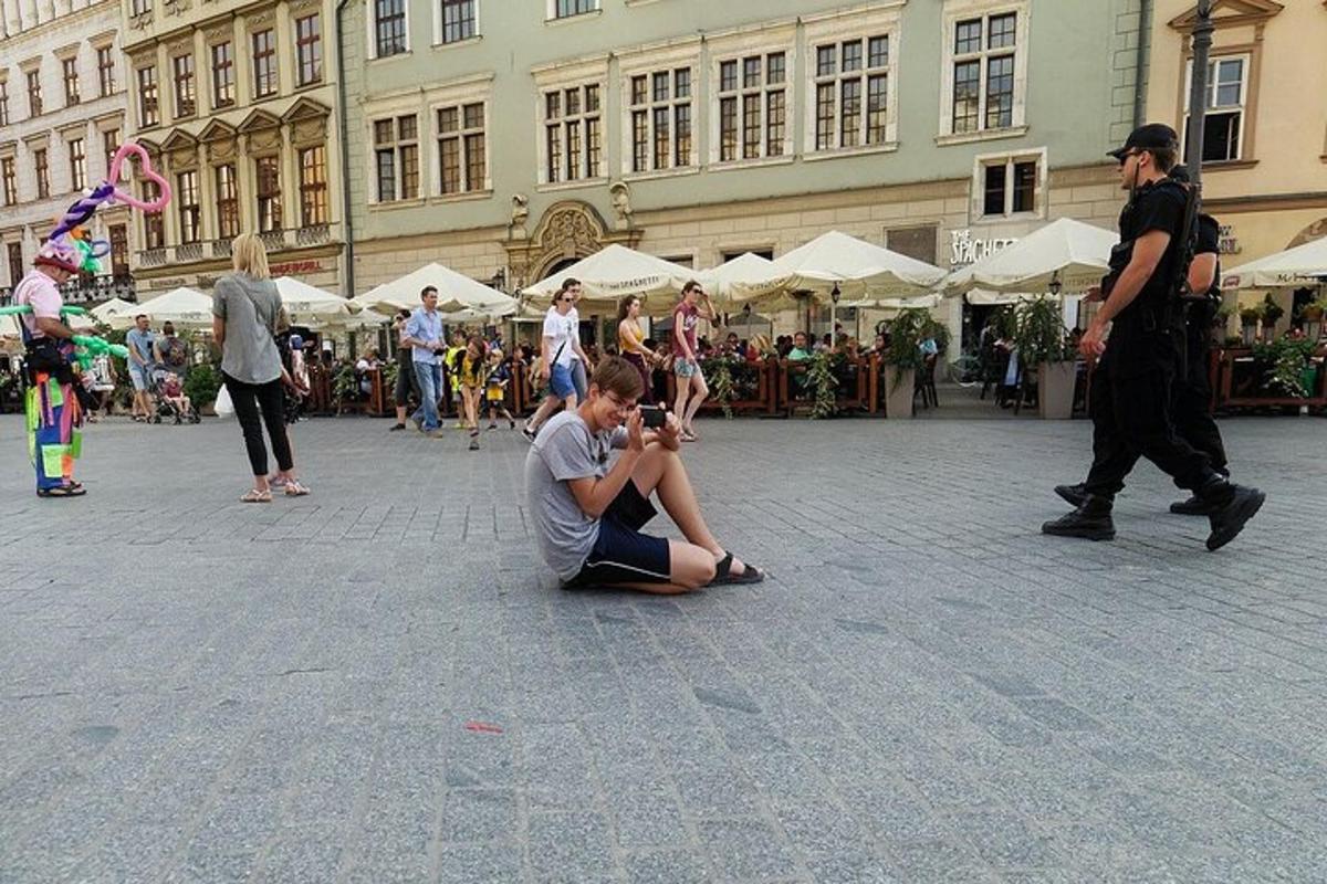 muž sedící na zemi na ulici s mužem jdoucím