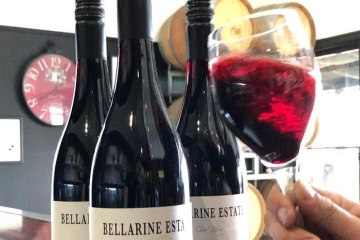 a person holding two bottles of red wine