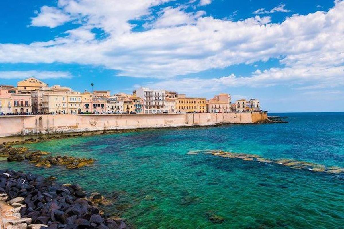 a group of buildings on the shore of the ocean