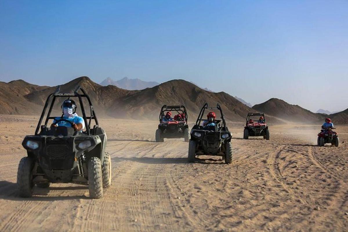 a group of people riding atvs in the desert