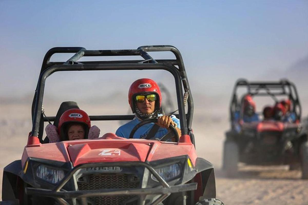 dalawang taong nakasakay sa isang four wheeler sa disyerto