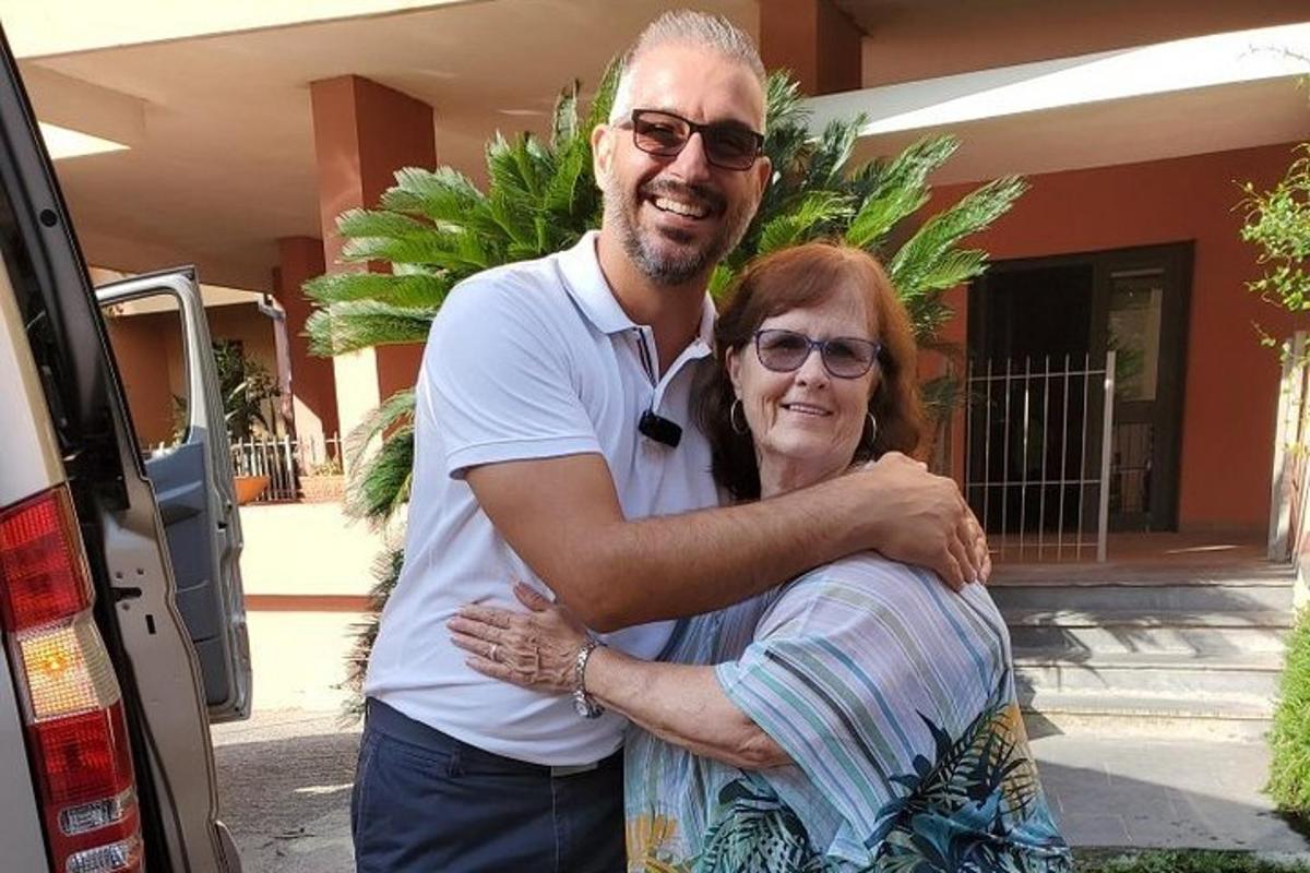 un uomo che abbraccia una donna davanti a un'auto