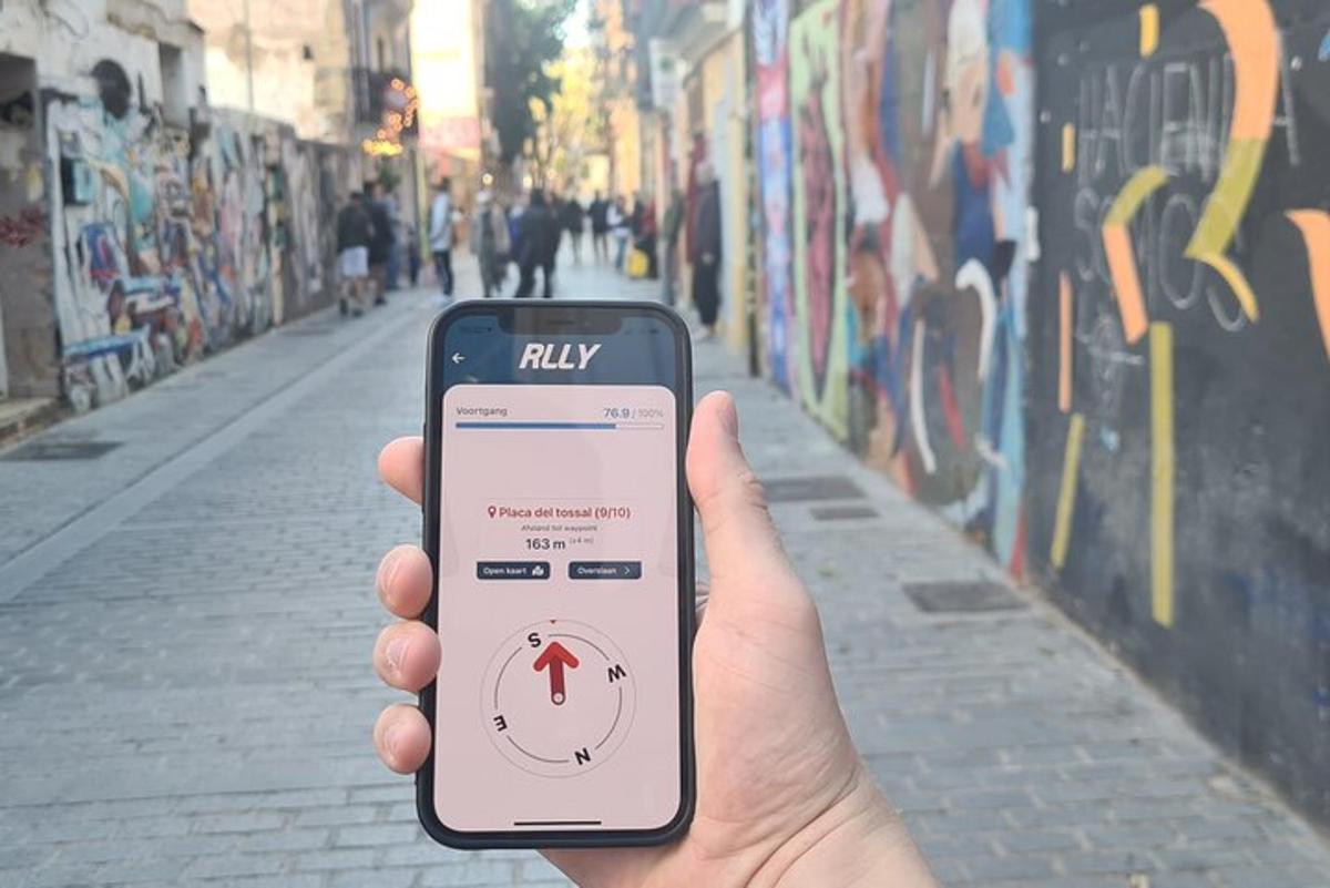 inimene, kes hoiab tänava ees mobiiltelefoni