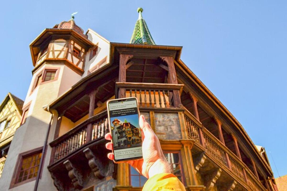 una persona che tiene in mano un telefono cellulare davanti a un edificio