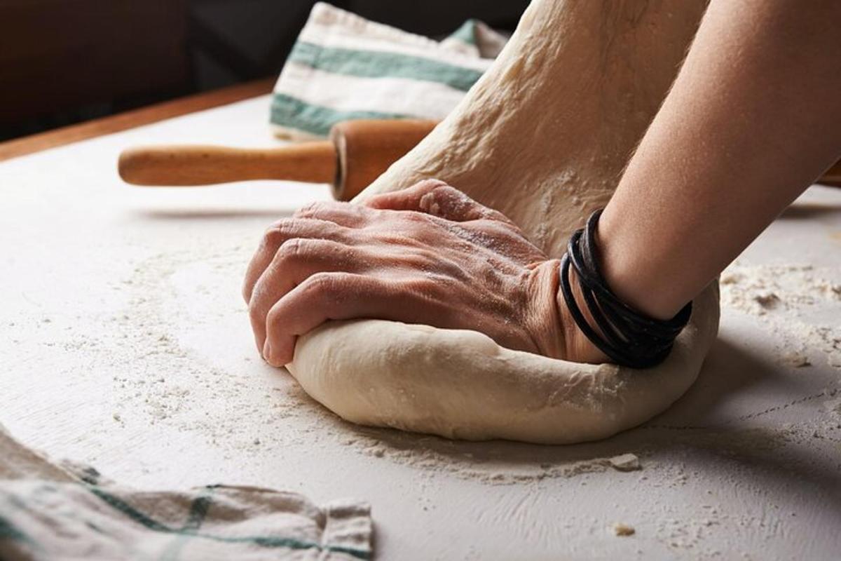 una persona che impasta un pezzo di pasta su un tavolo