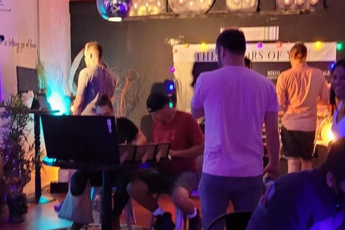 μια ομάδα ανθρώπων σε ένα δωμάτιο με έναν DJ