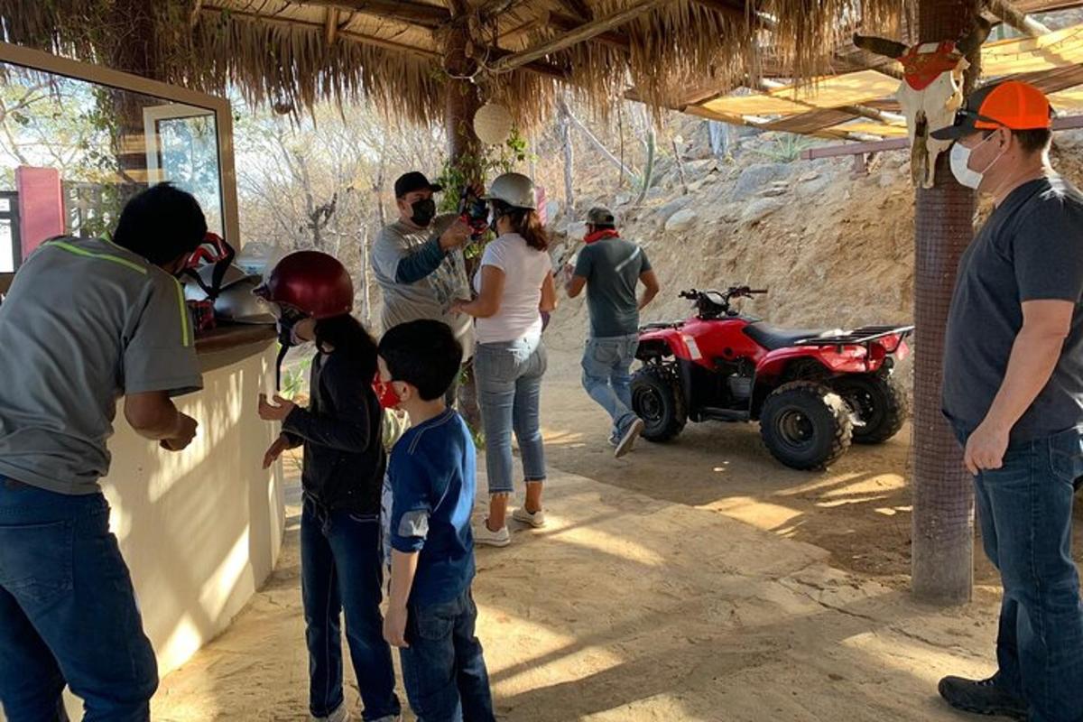 um grupo de pessoas em pé em uma garagem com um quadriciclo