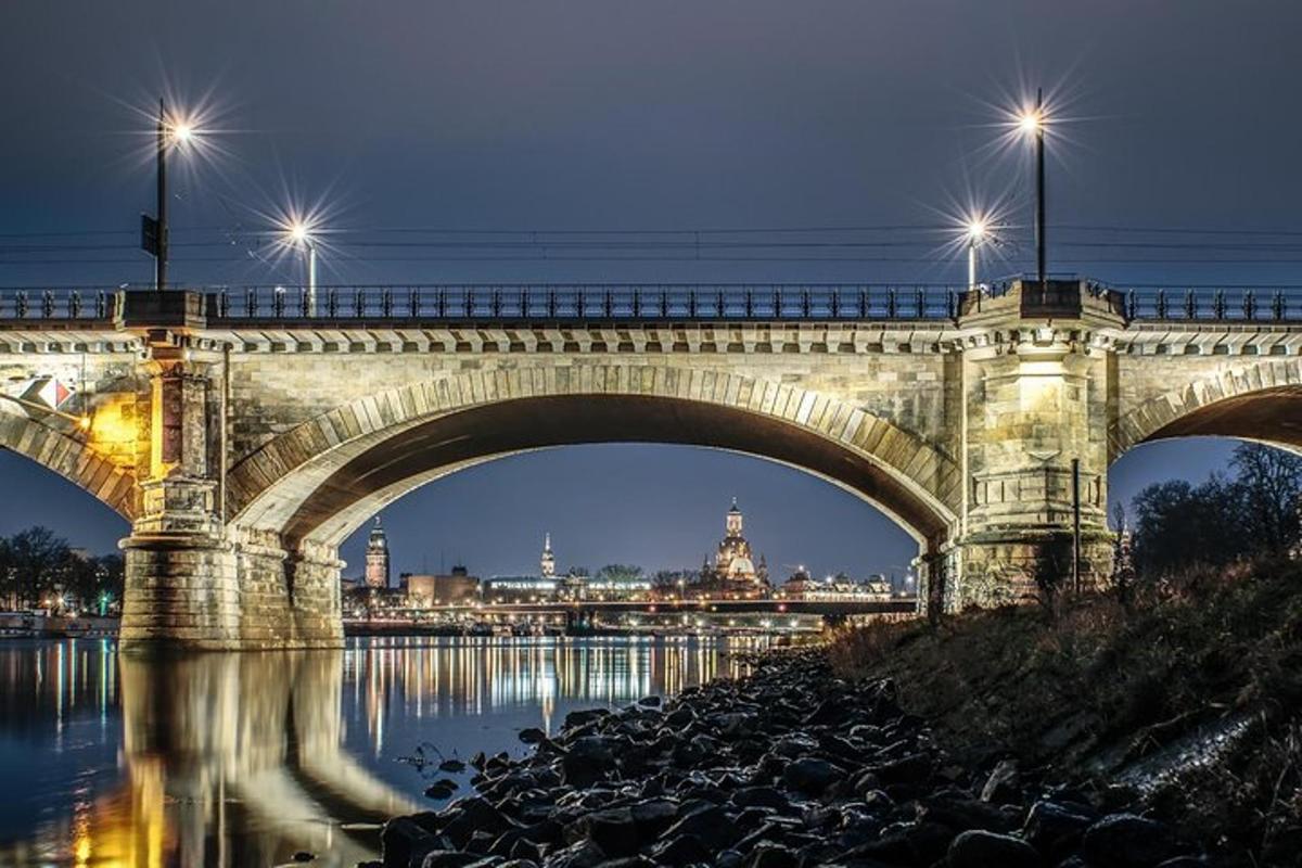 un pont sobre l'aigua a la nit amb llums