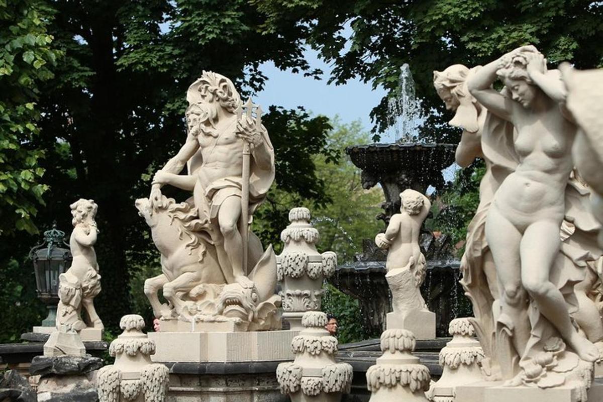 en fontene med hvite statuer i en park