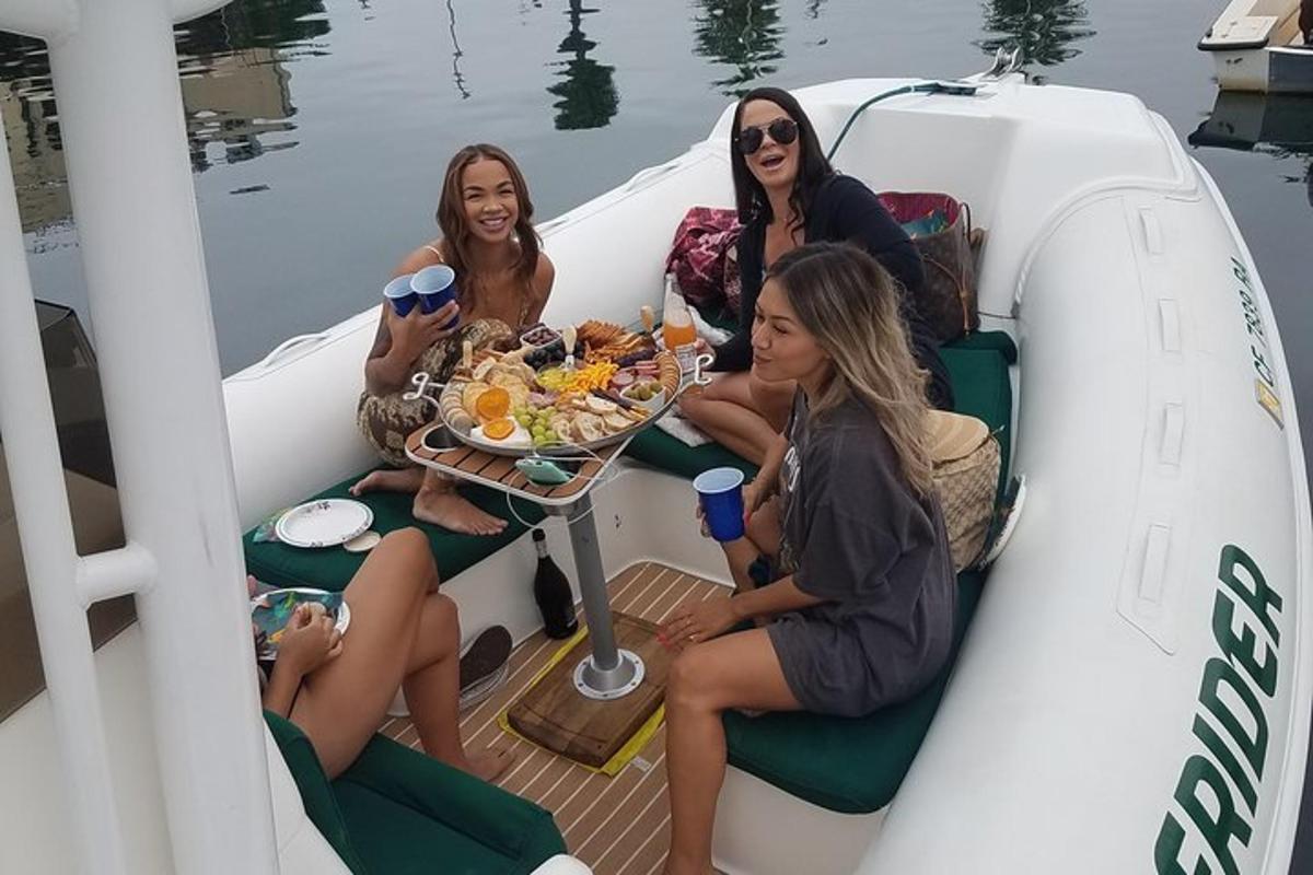 tre donne sedute su una barca con un piatto di cibo