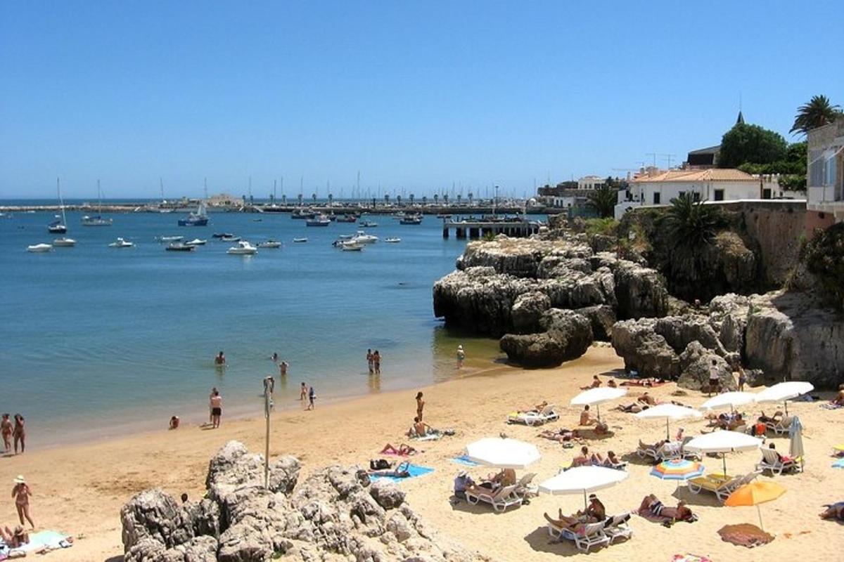 un gruppo di persone su una spiaggia con barche in acqua