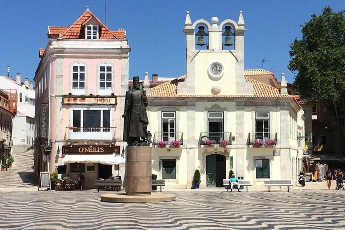 una statua di fronte a un edificio con una torre dell'orologio