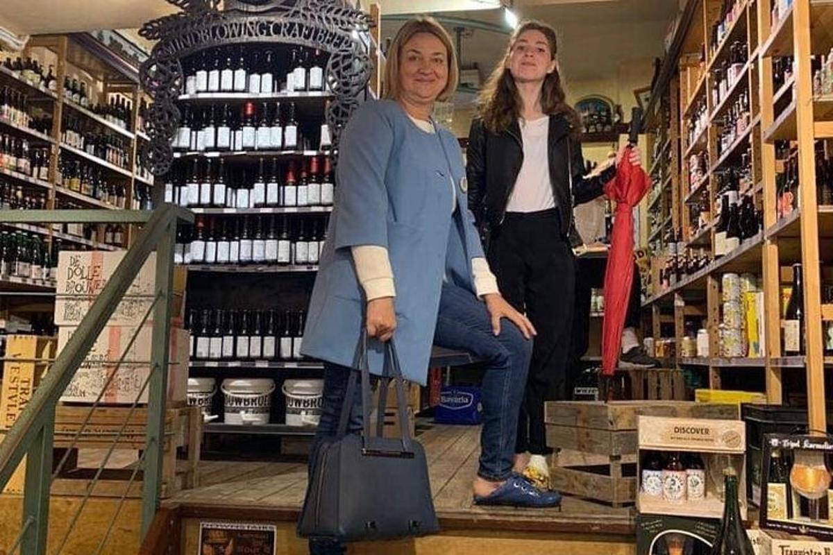 dues dones estan dretes en una botiga amb ampolles de vi