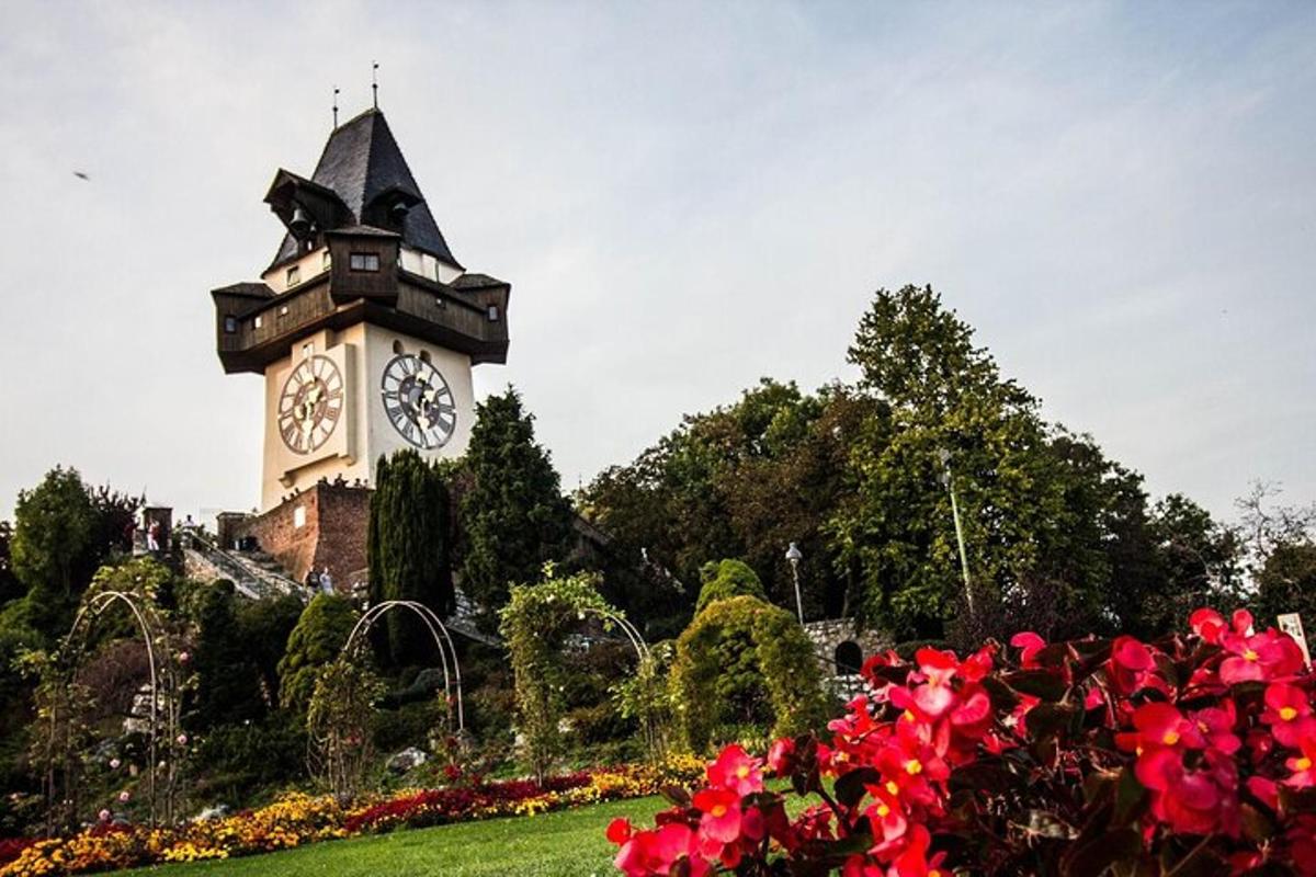 et klokketårn midt i en park med blomster