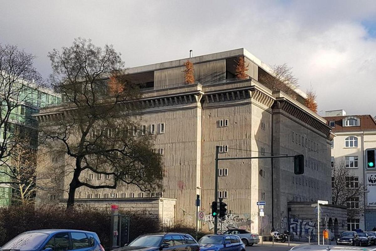 un grande edificio con auto parcheggiate di fronte