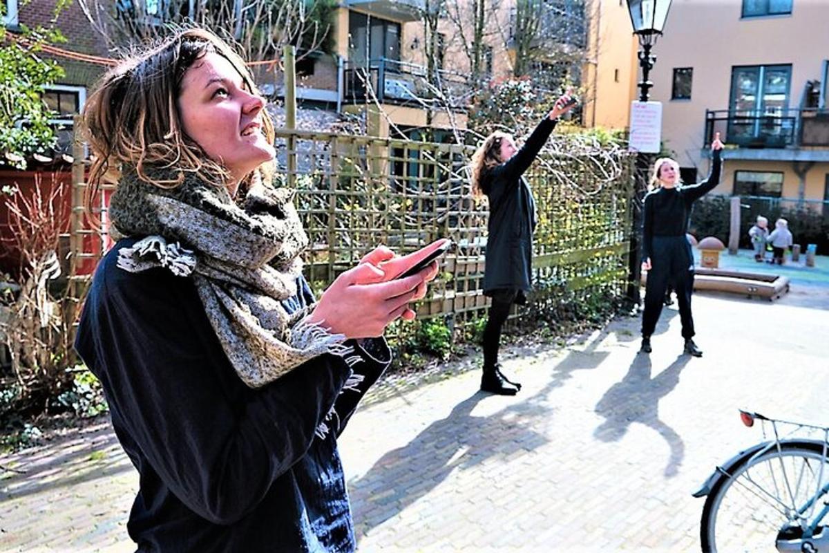 Hópur kvenna stendur á gangstétt og horfir á farsíma sína