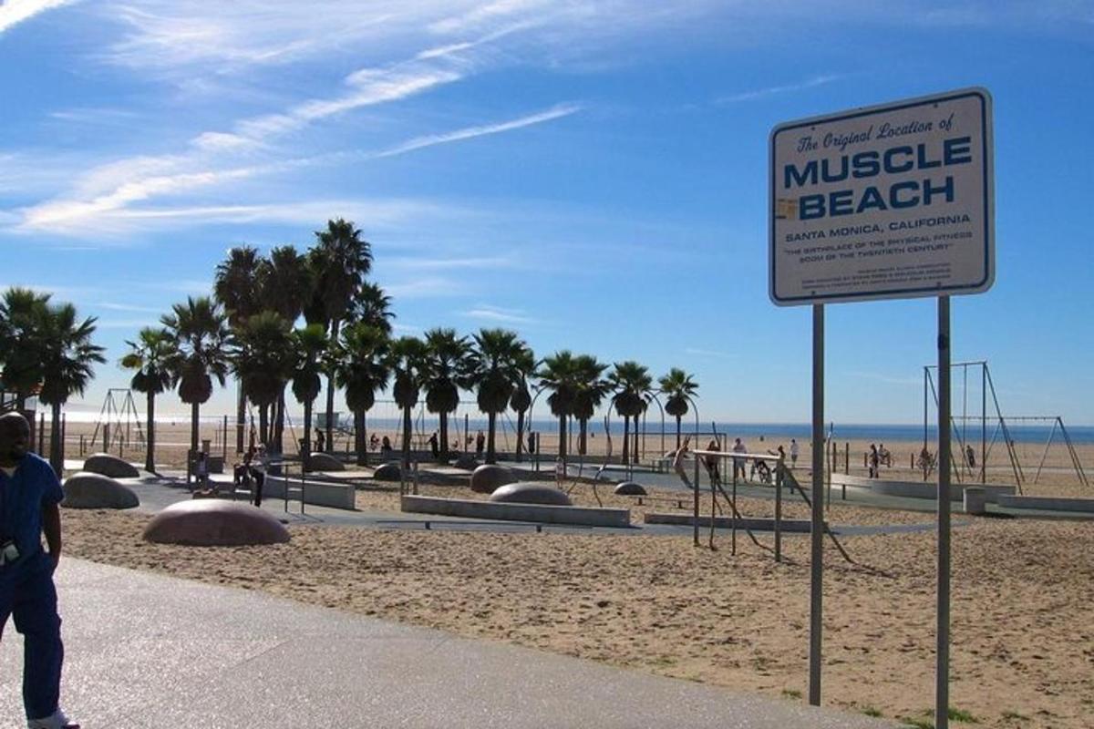 a sign in front of a beach with palm trees