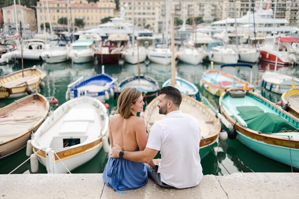 a man and a woman sitting on a dock with boats