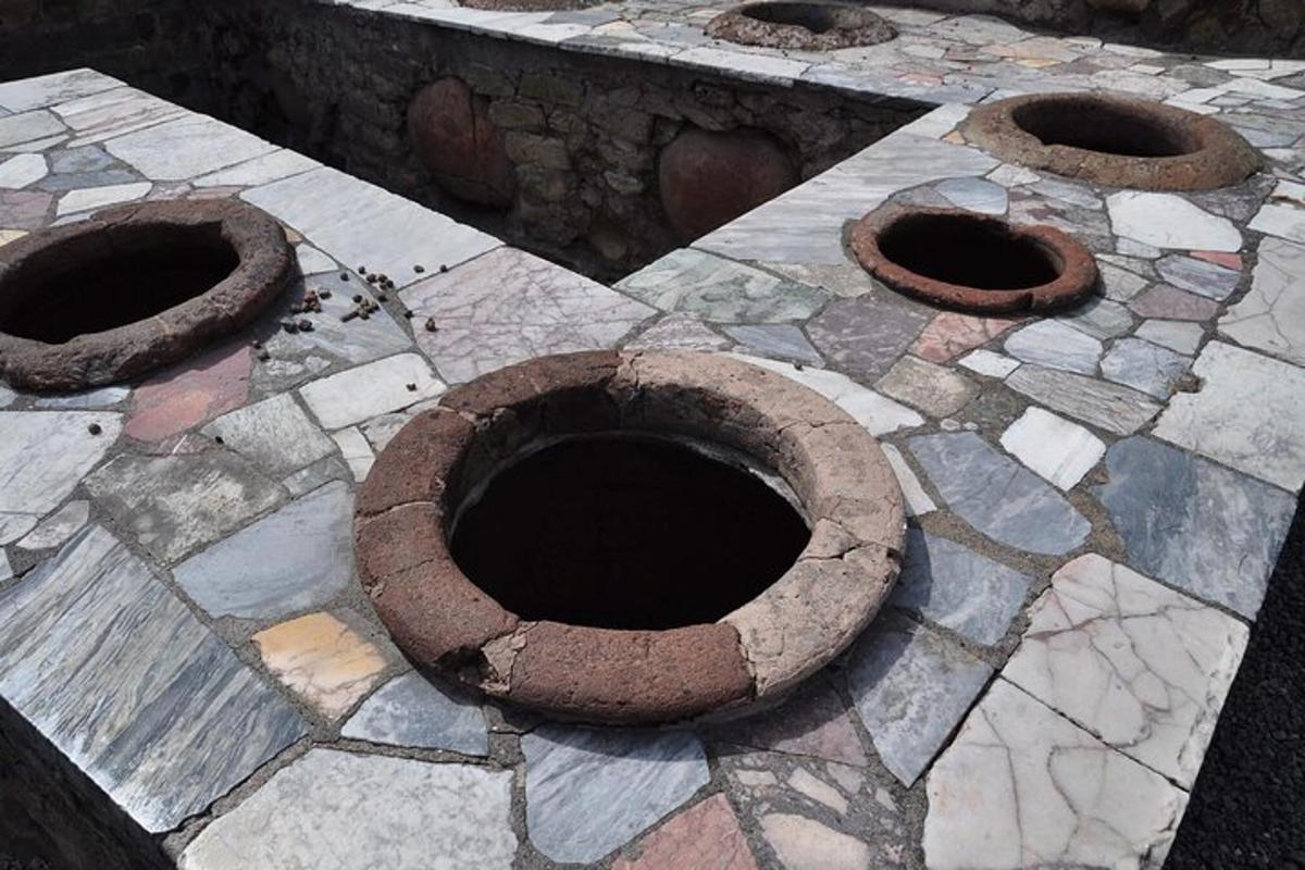 a group of three cement bowls on a stone ground