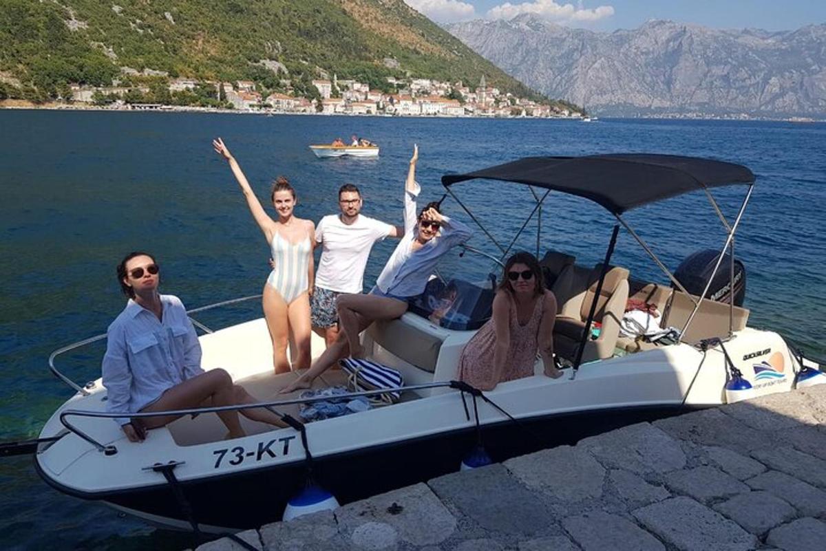 hópur fólks situr í bát á vatninu