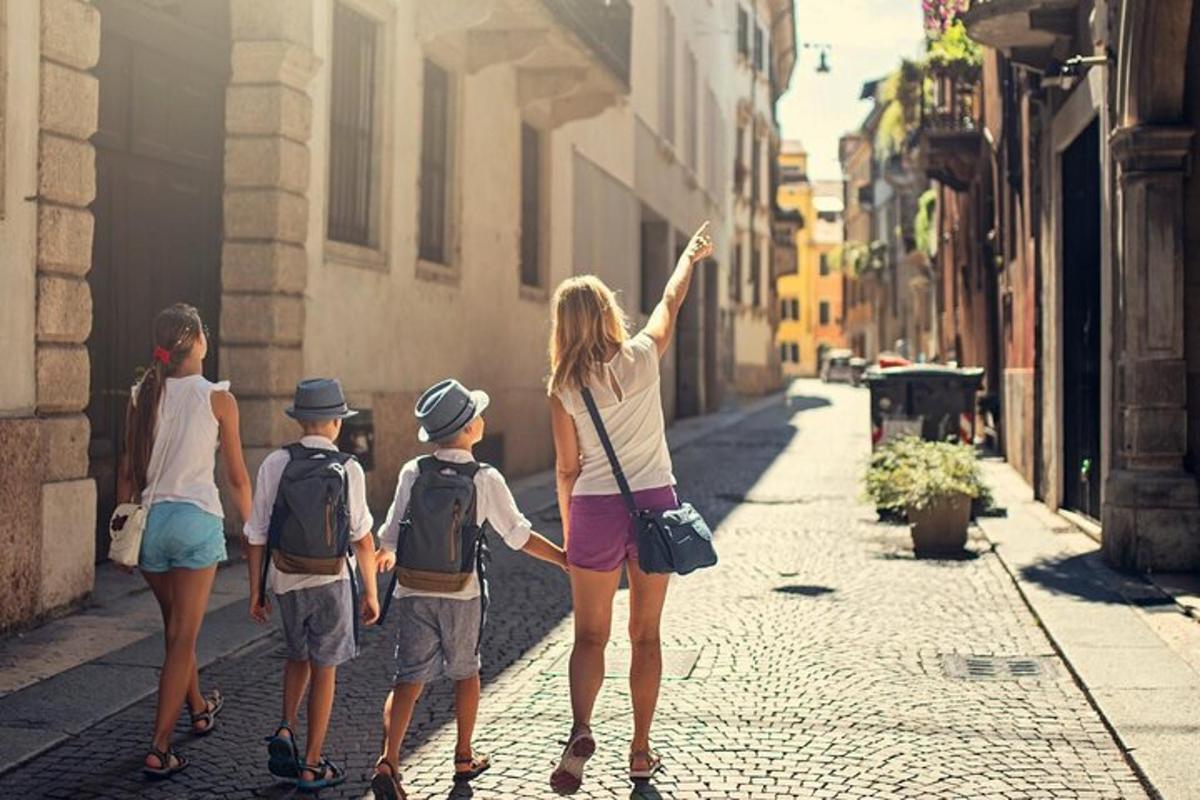 naine ja kolm last kõnnivad mööda tänavat