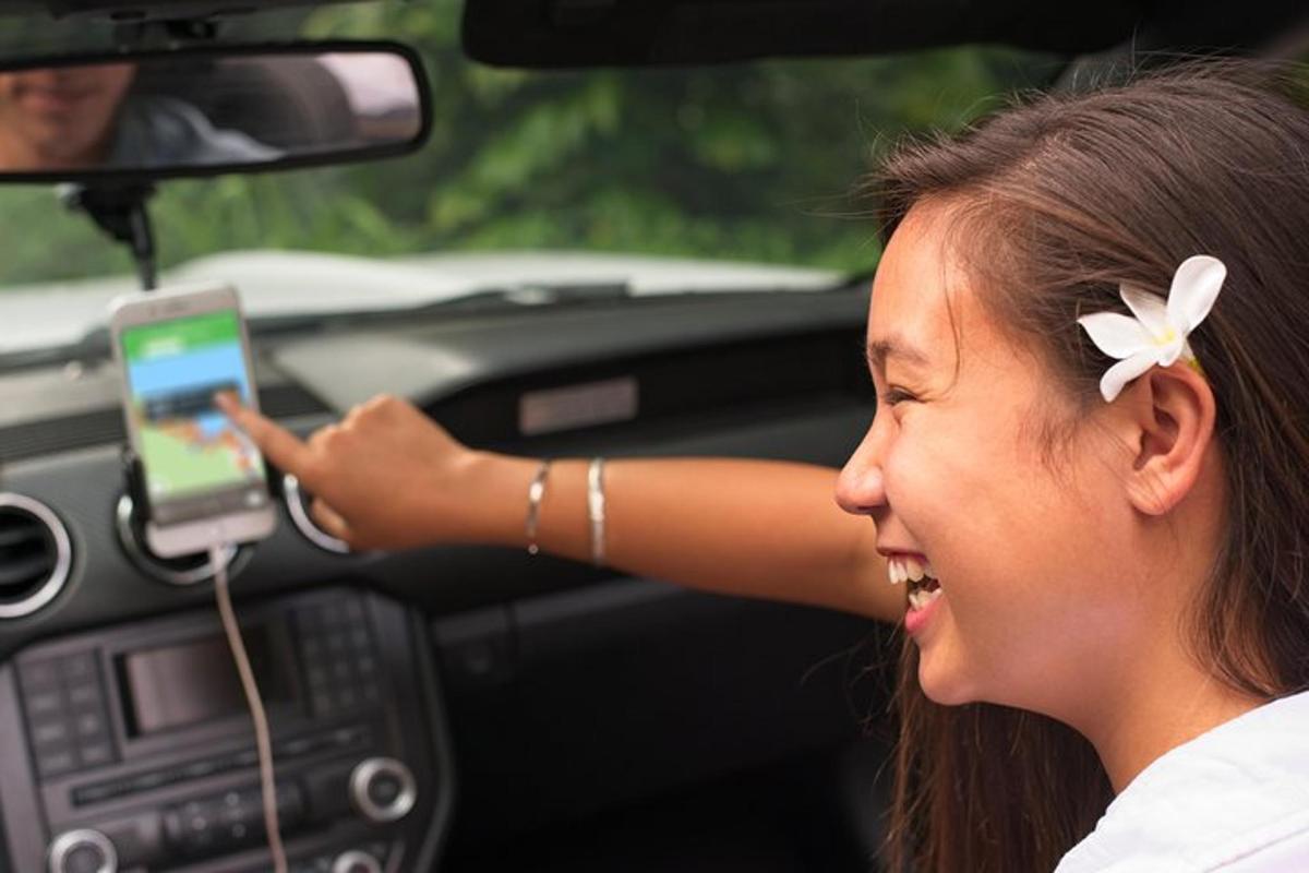 seorang wanita dengan bunga di rambutnya memegang telefon bimbit