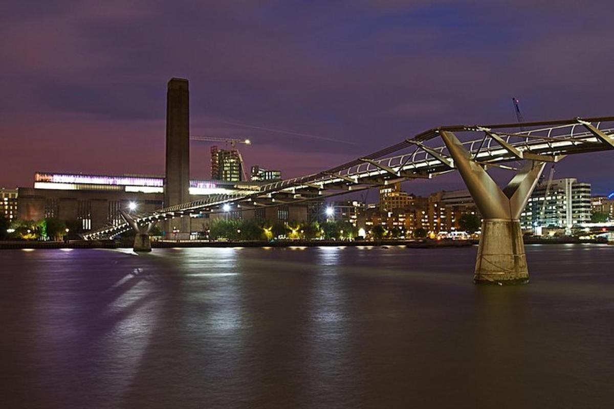 a bridge over a river with a city at night